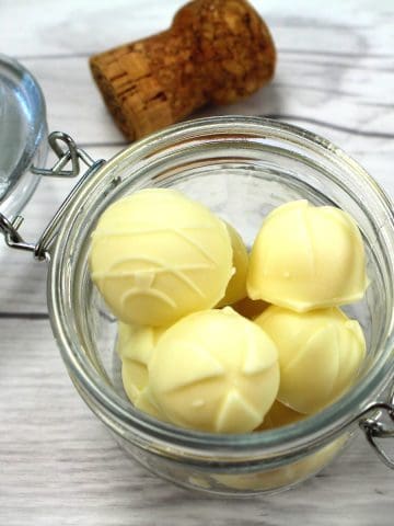 White chocolate truffles on a decorative plate.