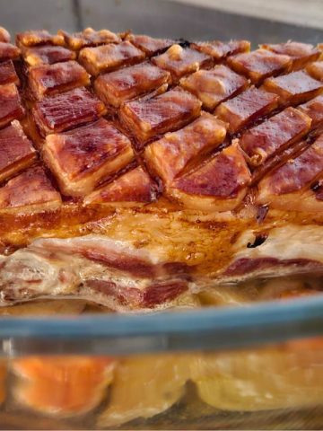 German pork roast with crispy crackling in a glass casserole dish.